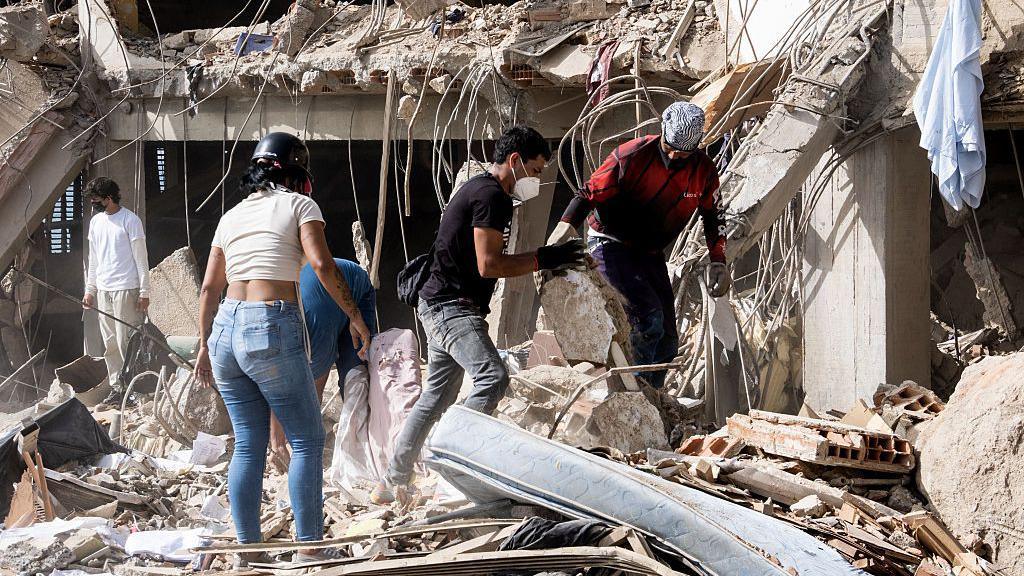 Family members and volunteers search through the rubble after two 17-story buildings in the Belo Horizonte residential complex collapsed in Catia La Mar, La Guaira (Venezuela), on June 26, 2026.