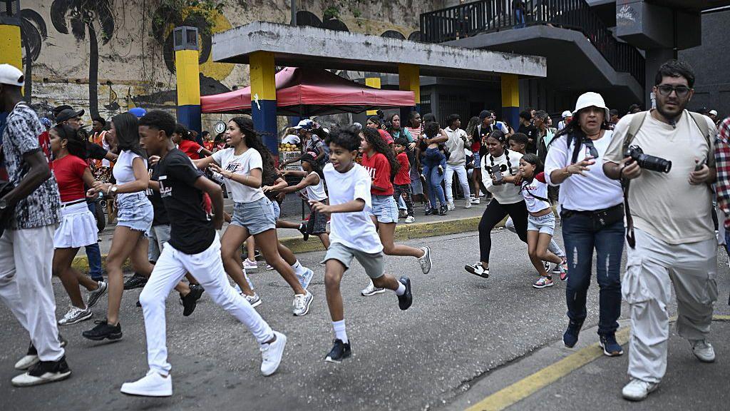 People run into a street away from buildings following an earthquake in Caracas, Venezuela on 24 June.
