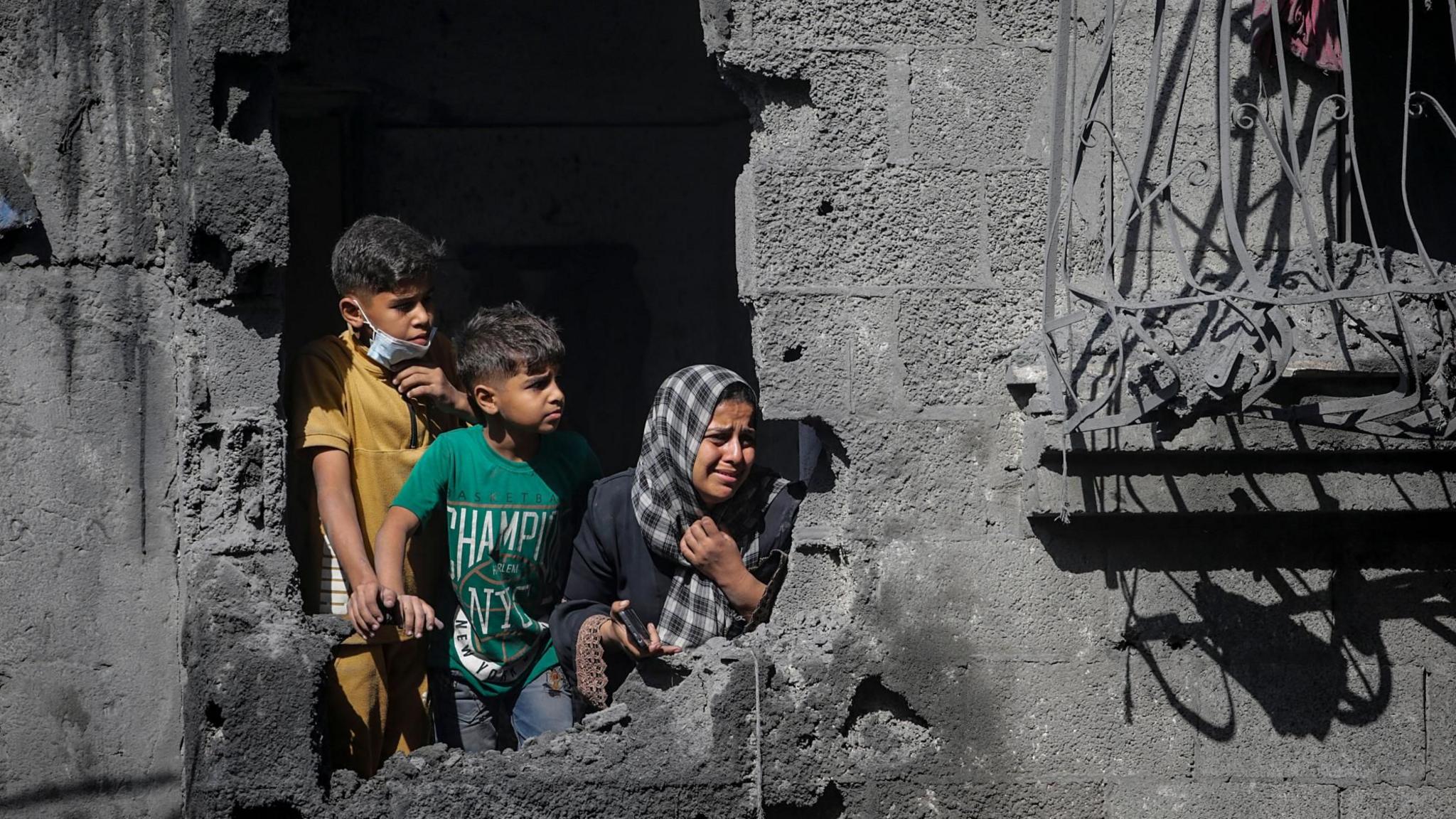 File photo showing Palestinian children looking out from their family's destroyed house following an Israeli air strike, in Shati refugee camp, northern Gaza (29 October 2025)