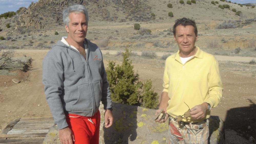 Jeffrey Epstein in a tracksuit top and Jean-Luc Brunel, with sunsglasses in his hand, pose in an undated photo released by the U Department of Justice