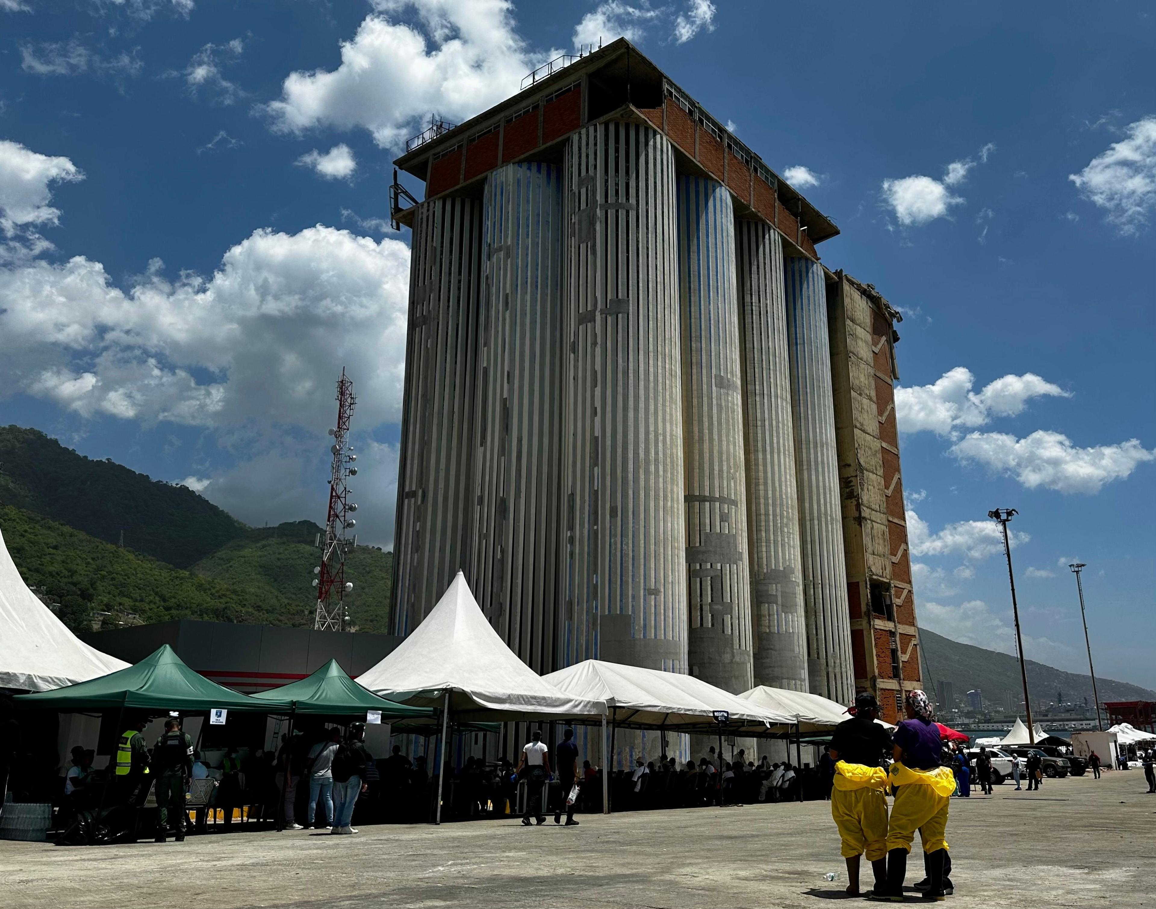 Los Silos facilities, dominated by a large, 36-meter-tall tower. White tents and people in hasmat suits stand in front.