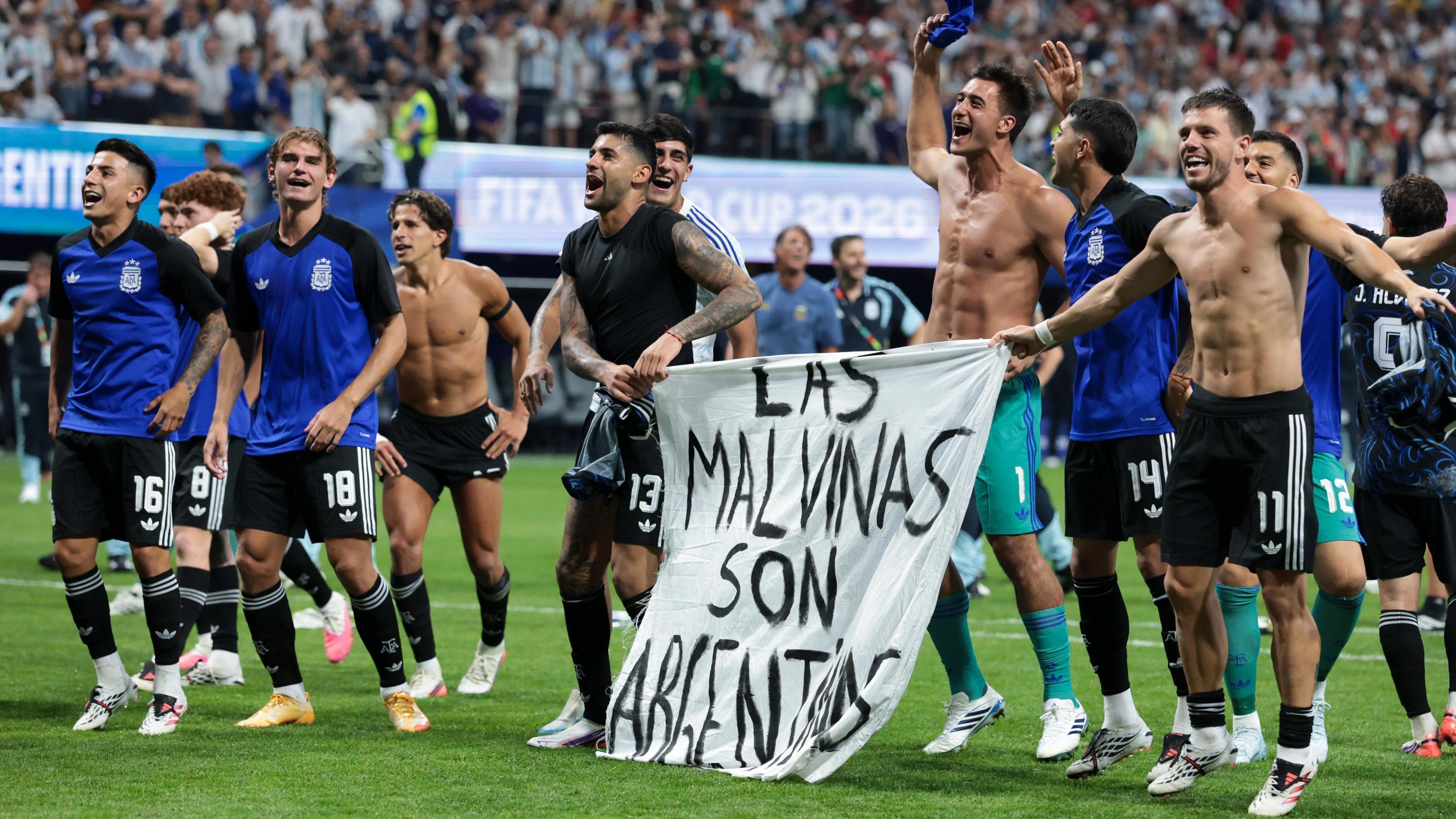 Argentina players celebrate at full-time with a banner that reads "The Falkland Islands are Argentine" after beating England in the World Cup 2026 semi-final