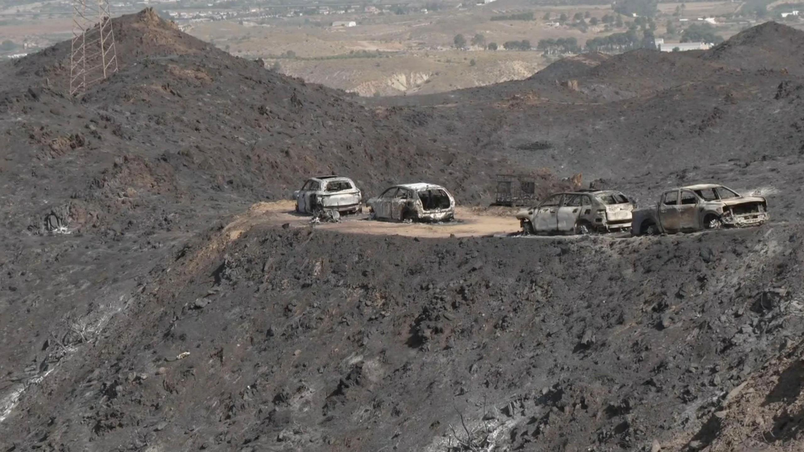 Four cars surrounded by the ashes in the aftermath of a wildfire in Spain.