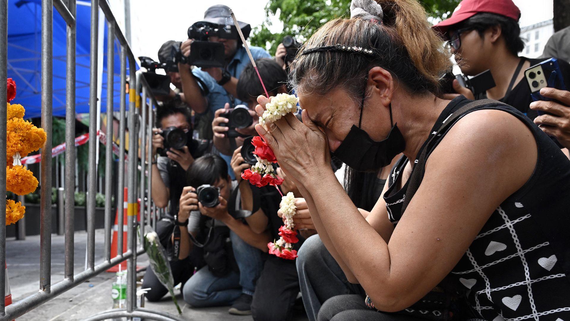 A woman prays for her deceased daughter and her son-in-law Suwitcha Sirililung in front of the Rong Beer Na Lat Phrao bar in Bangkok on July 14, 2026.
