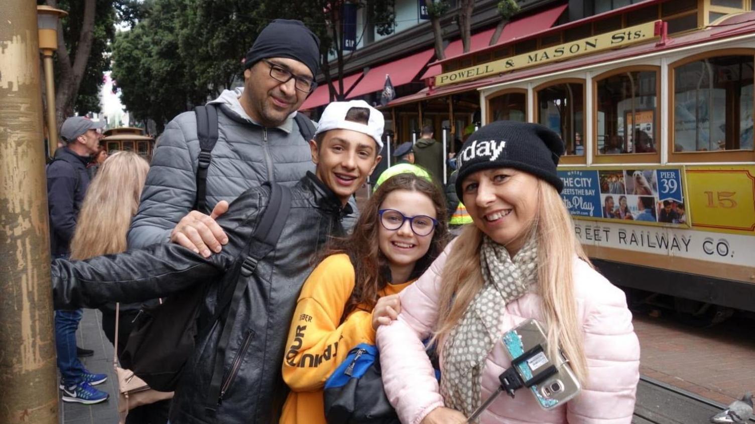 A man, a woman and two children smile at the camera