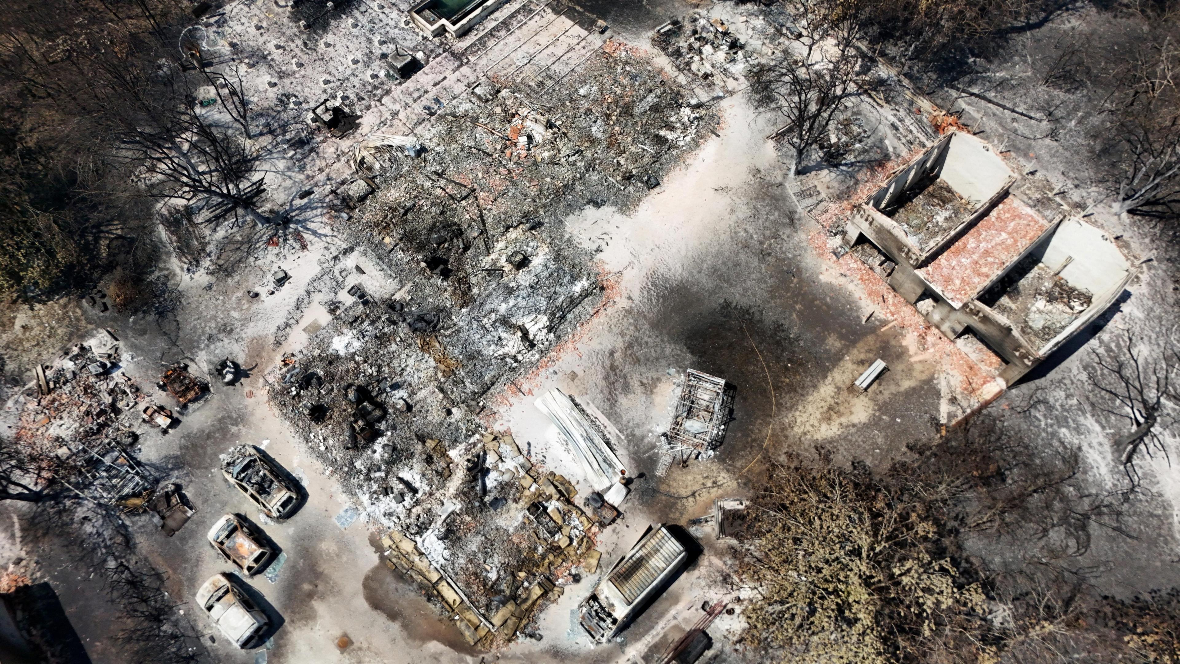 Drone view showing burnt-out houses and cars in Le Porge