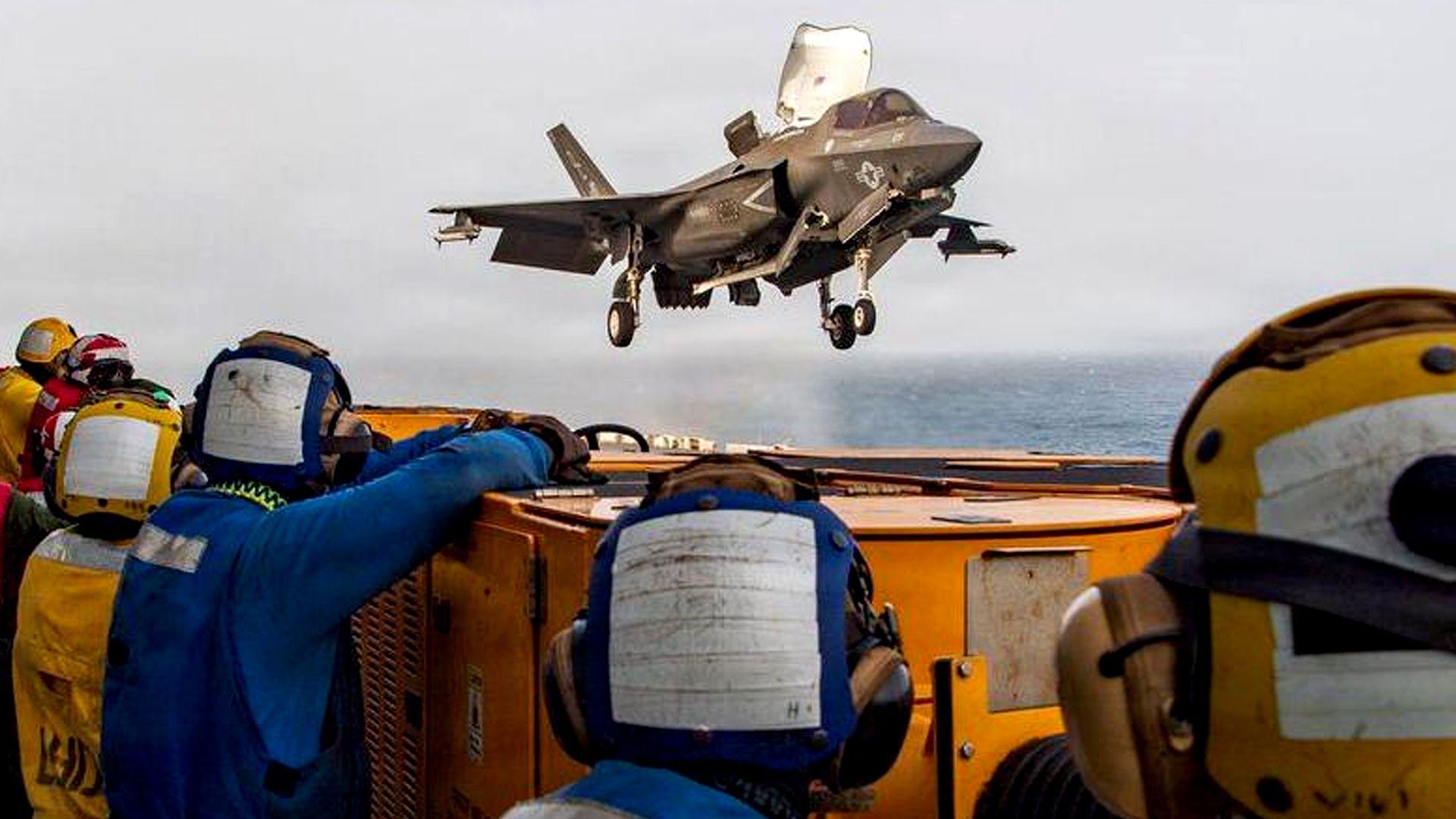 US service members aboard the USS Boxer amphibious assault ship watch a US fighter jet in flight. File photo