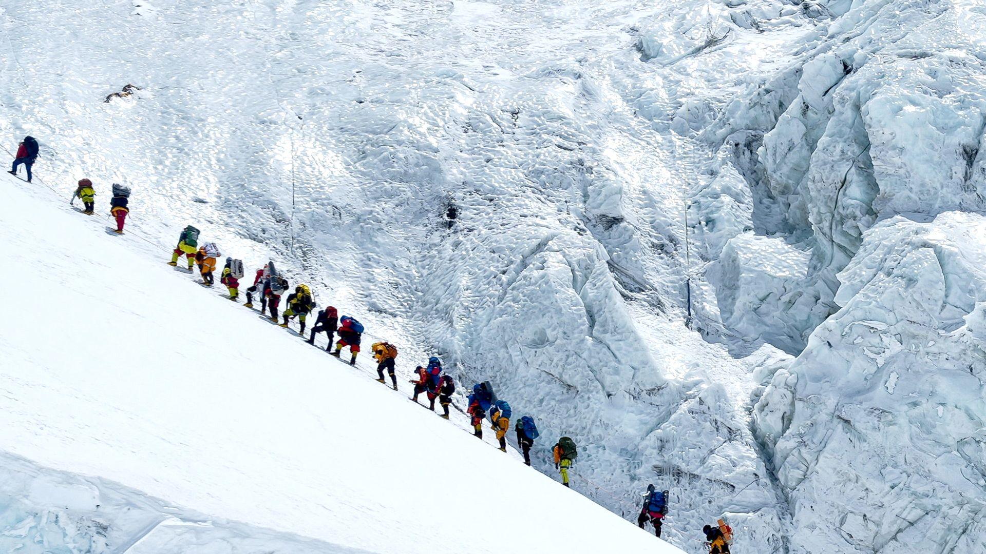Climbers walk in a long queue as they head to summit Mount Everest in the Solukhumbu distric