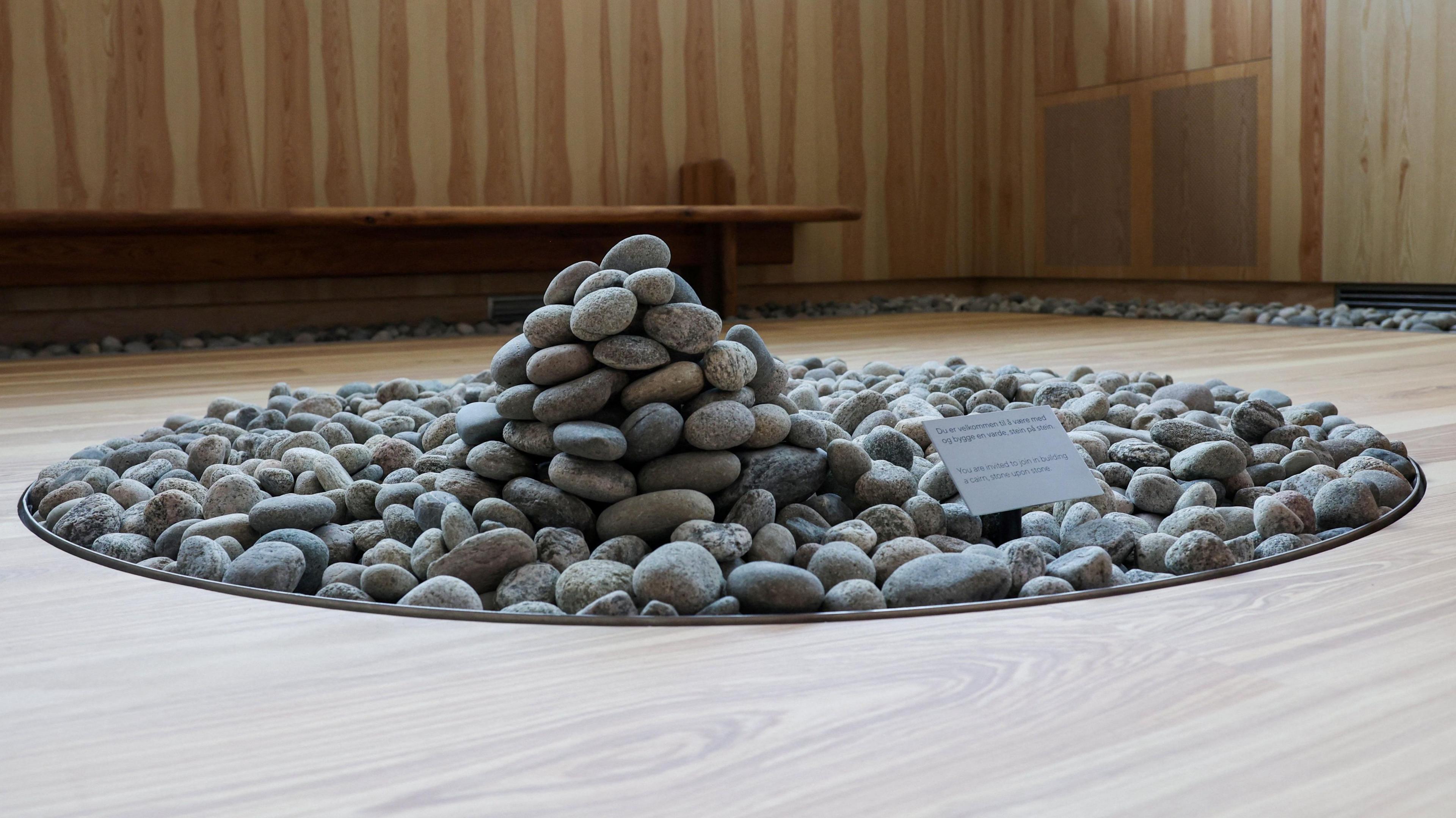 Pebble artwork in Oslo memorial for 2011 massacre victims - a pile of pebbles in a circular space inside a room