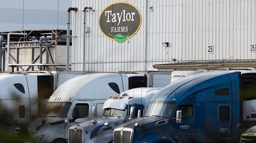 View of Taylor Farms building with trucks in front of it