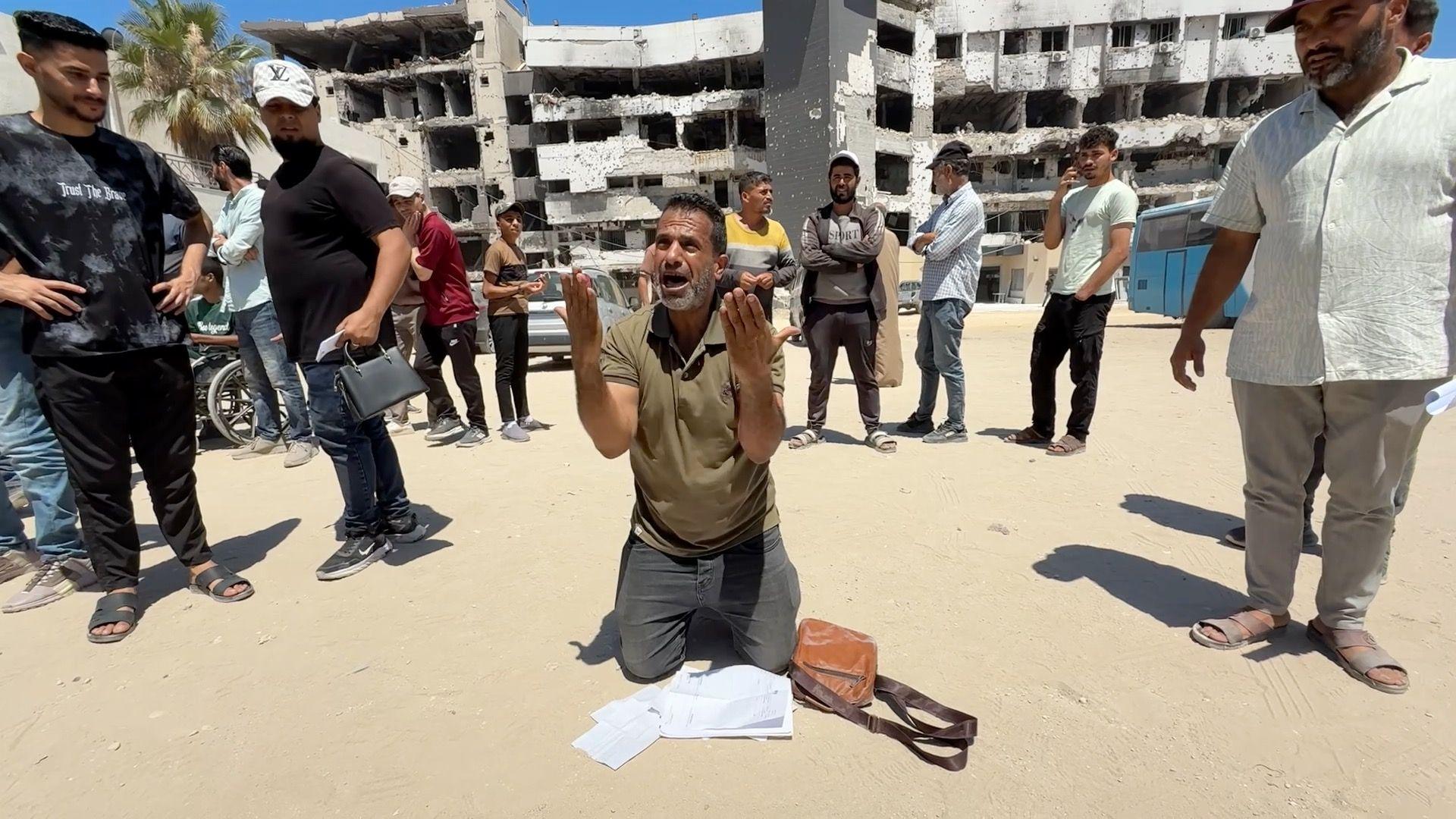 A man waiting for a medical evacuation kneels outside al-Shifa hospital in Gaza City, northern Gaza