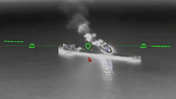 A still image of an oil tanker under attack from a drone in a black and while nighttime image