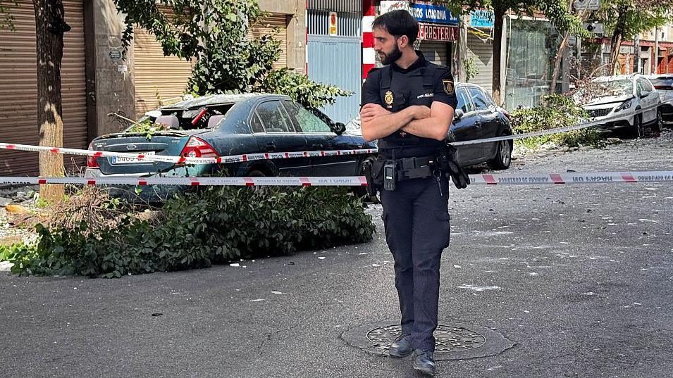 A policeman stands at a cordoned off street near damaged vehicles following an earthquake in Granada, southern Spain. Photo: 18 August 2026
