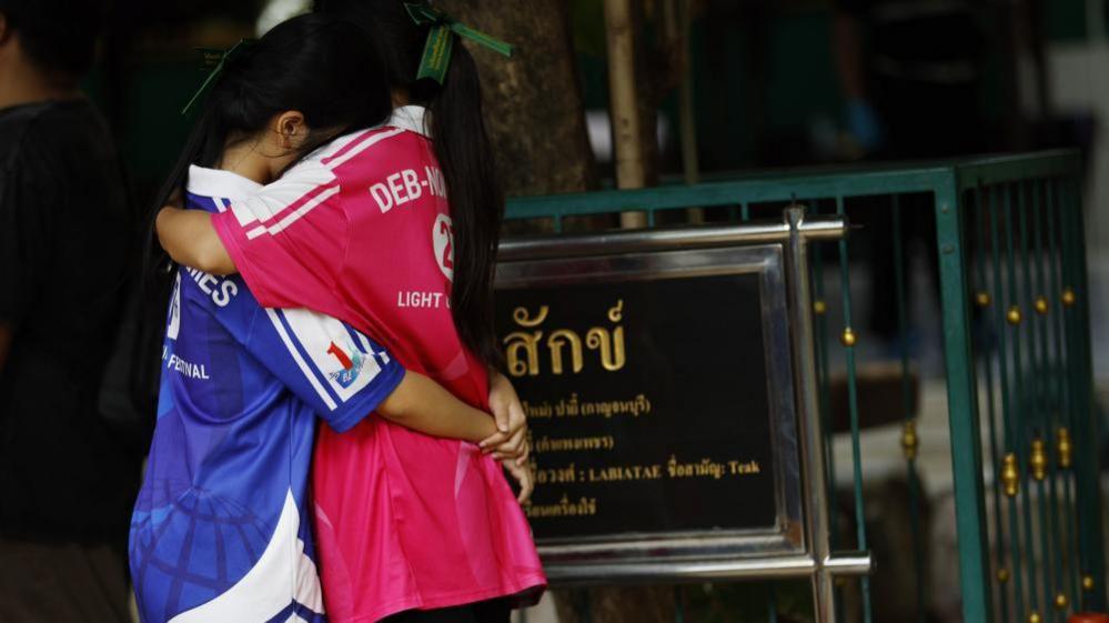 Students embrace each other following a school shooting at Debsirin Nonthaburi School