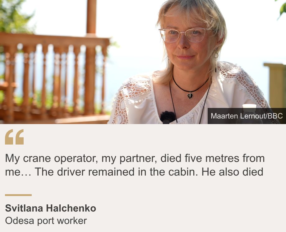 "My crane operator, my partner, died five metres from me… The driver remained in the cabin. He also died", Source: Svitlana Halchenko , Source description: Odesa port worker, Image: Svitlana Halchenko sits in a white shirt and glasses on a wooden deck overlooking the sea.