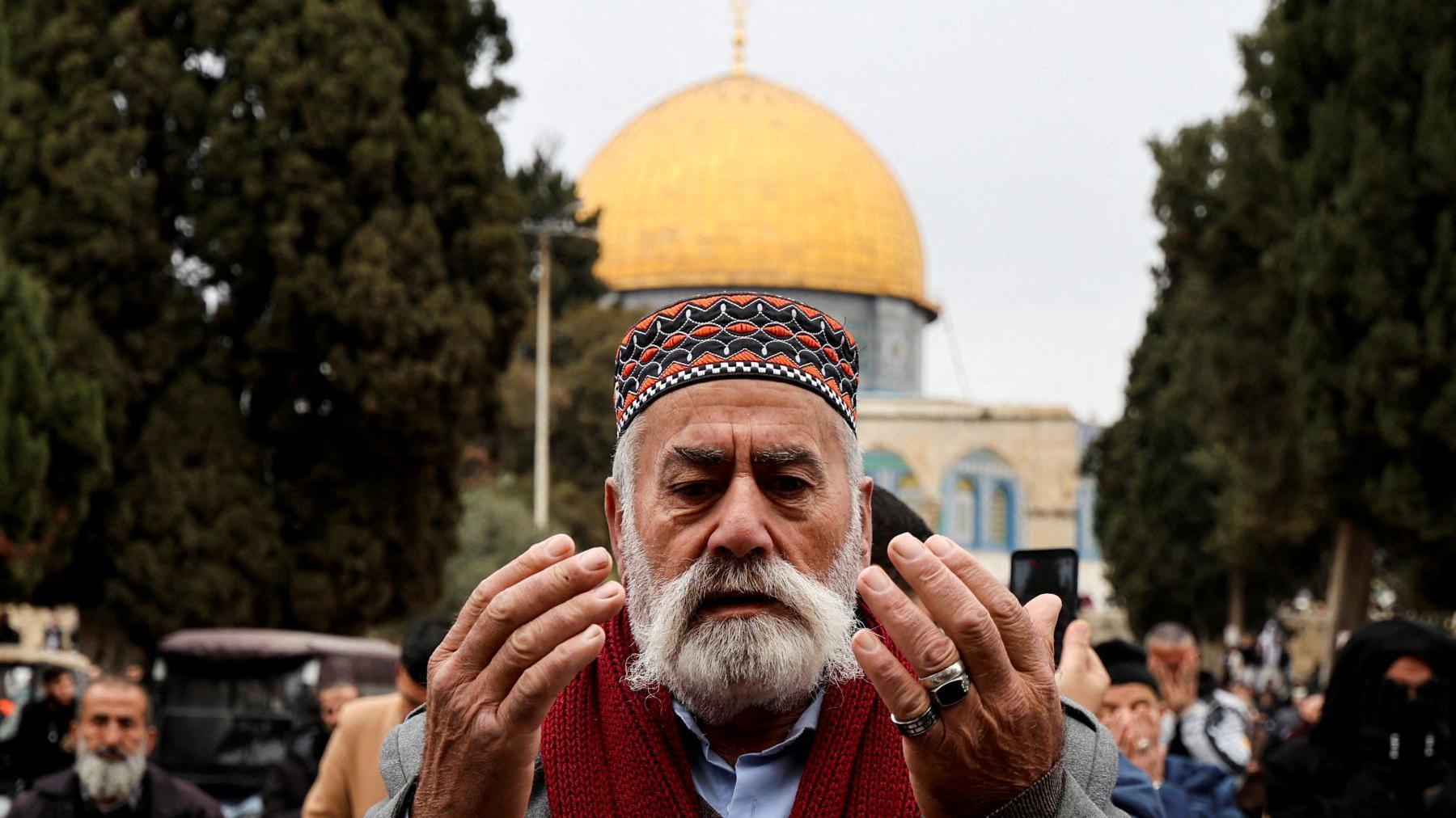 Muslim man prays outside the Dome of the Rock at the start of Ramadan 2025