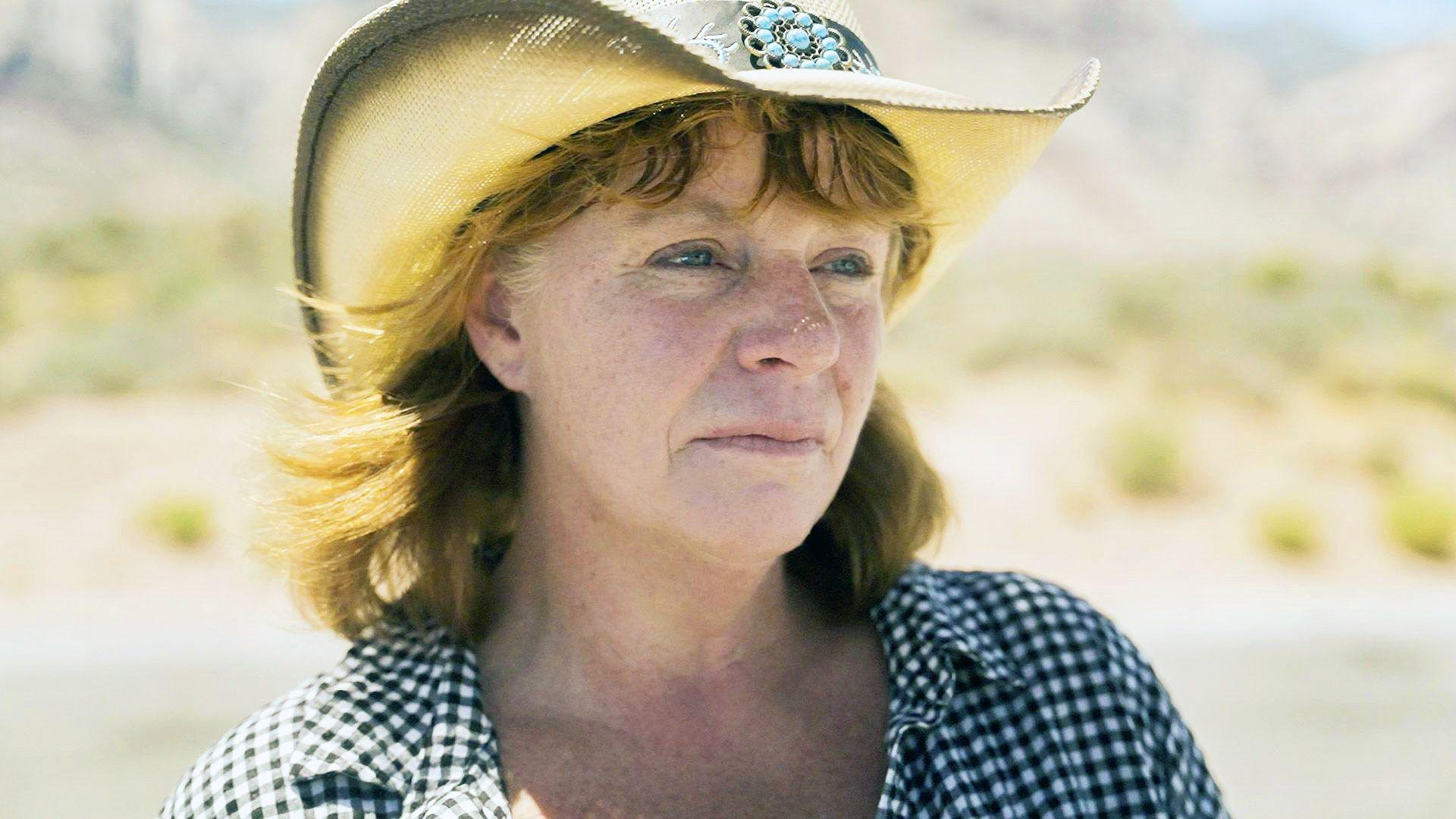 Holly Ratchford wears a straw cowboy hat while standing in the desert in an undisclosed location in the west of the United States.