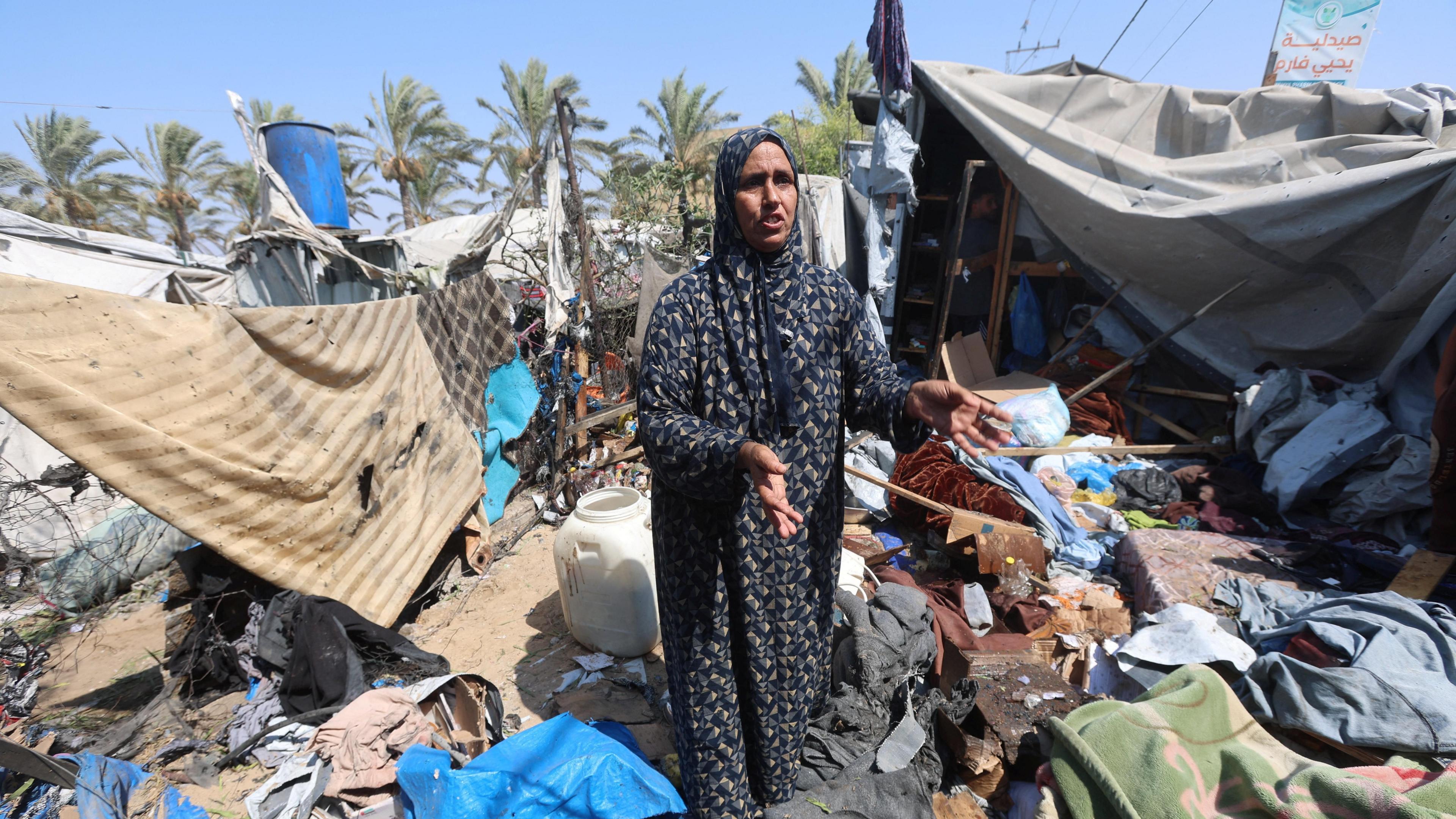 A Palestinian woman stands amid debris at a tent camp in Khan Younis.