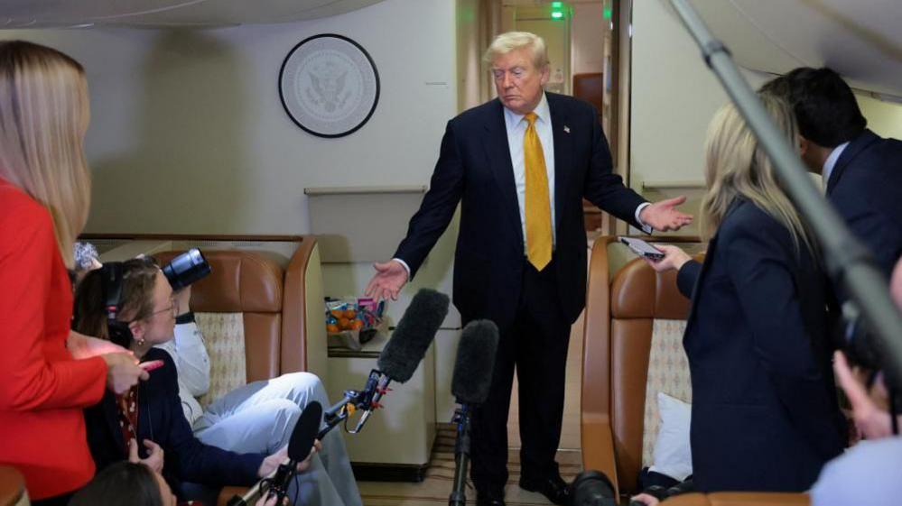 Trump speaks to reporters on the flight from the UK to the US