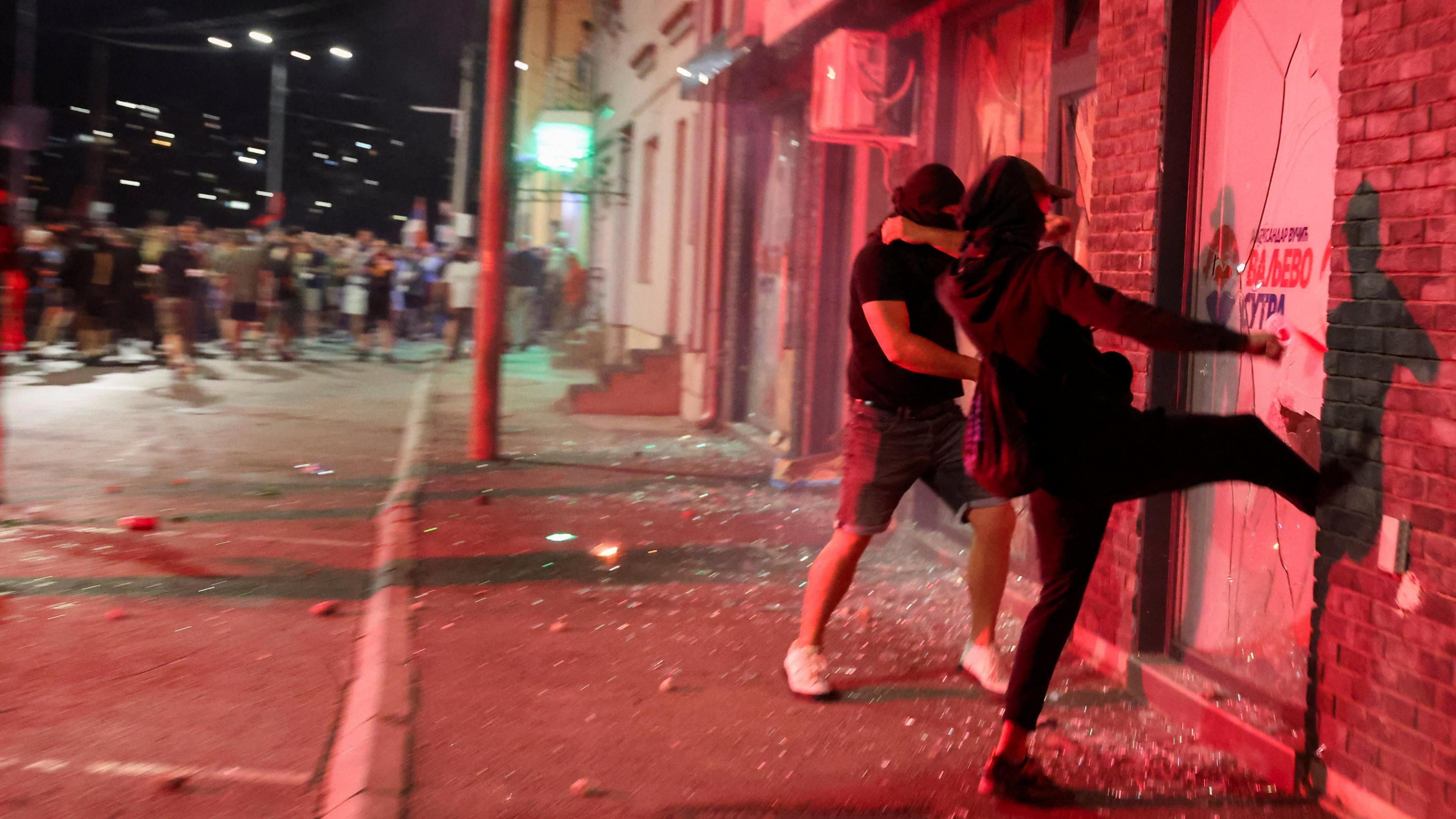 Anti-government protesters break the windows of the offices of the ruling Serbian Progressive Party