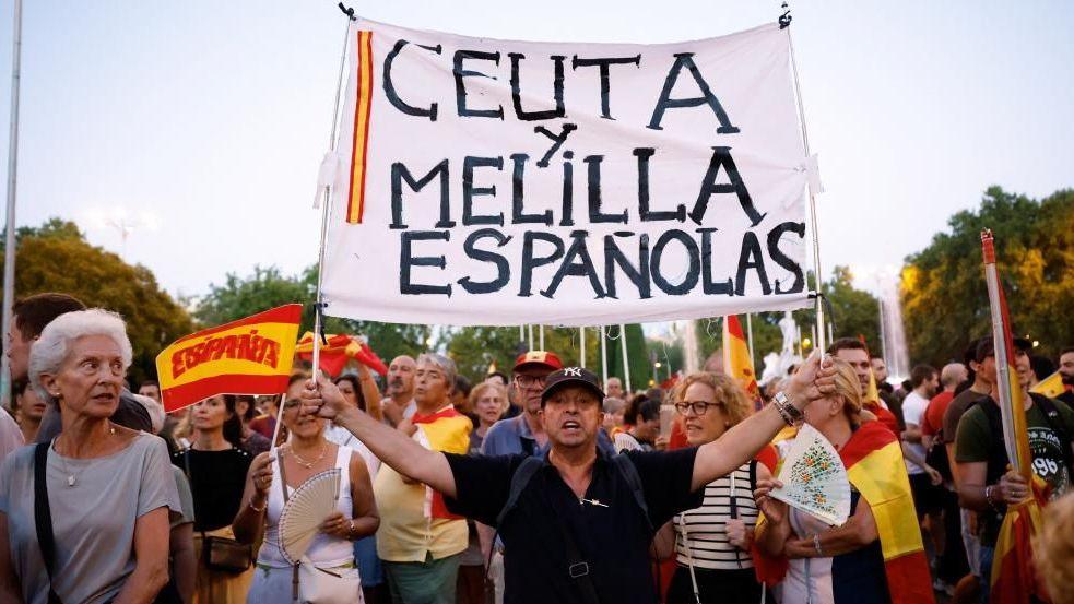 Protesters hold flags and a sign during a demonstration in support of residents of Spain's North African enclave of Ceuta following recent mass crossings of migrants from Morocco, in Madrid, Spain, September 2, 2026.