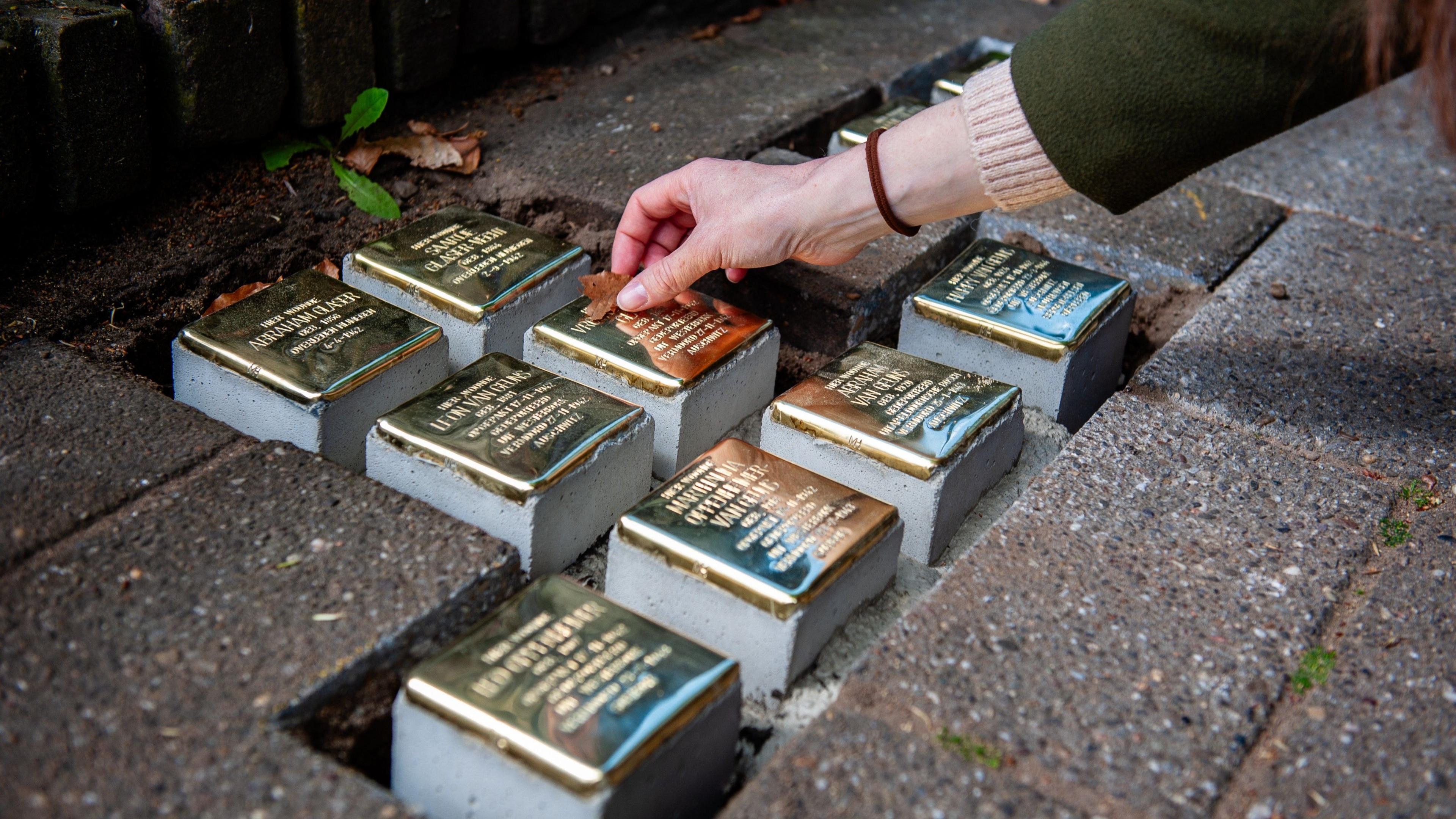 Small blocks of stone with brass on top are placed as part of a memorial on the pavement in front of houses where Jewish victims lived in Nijmegen in the Netherlands