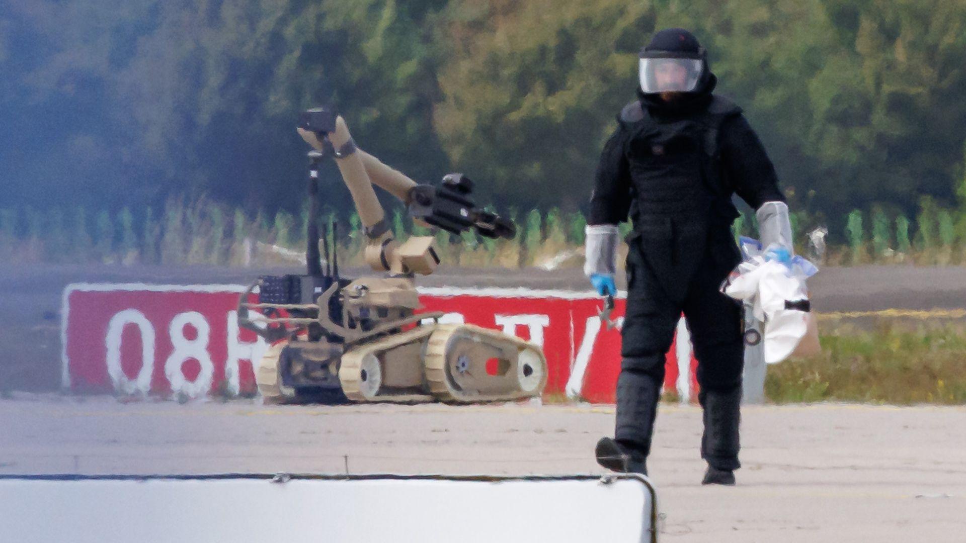 A police investigator works on the tarmac with a robot capable of defusing explosives near a Ukrainian Antonov cargo plane at Leipzig/Halle Airport on August 5, 2026 near Leipzig, Germany