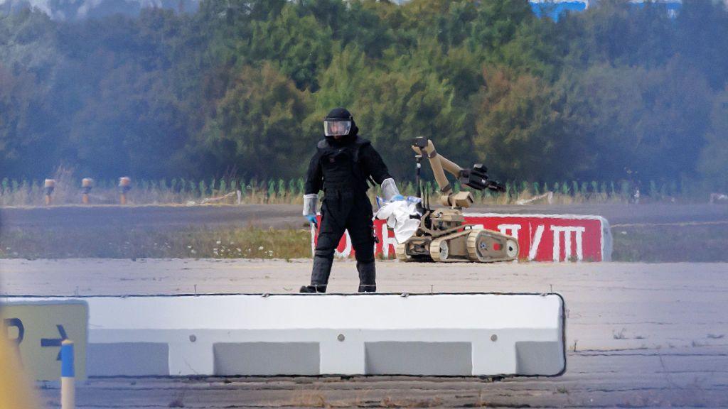 A police investigator works on the tarmac with a robot capable of defusing explosives near a Ukrainian Antonov cargo plane at Leipzig/Halle Airport on 5 August