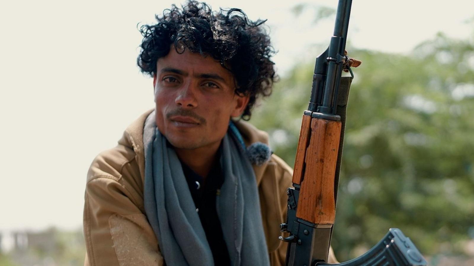 A Yemeni pro-government fighter holds a rifle in south-western Yemen