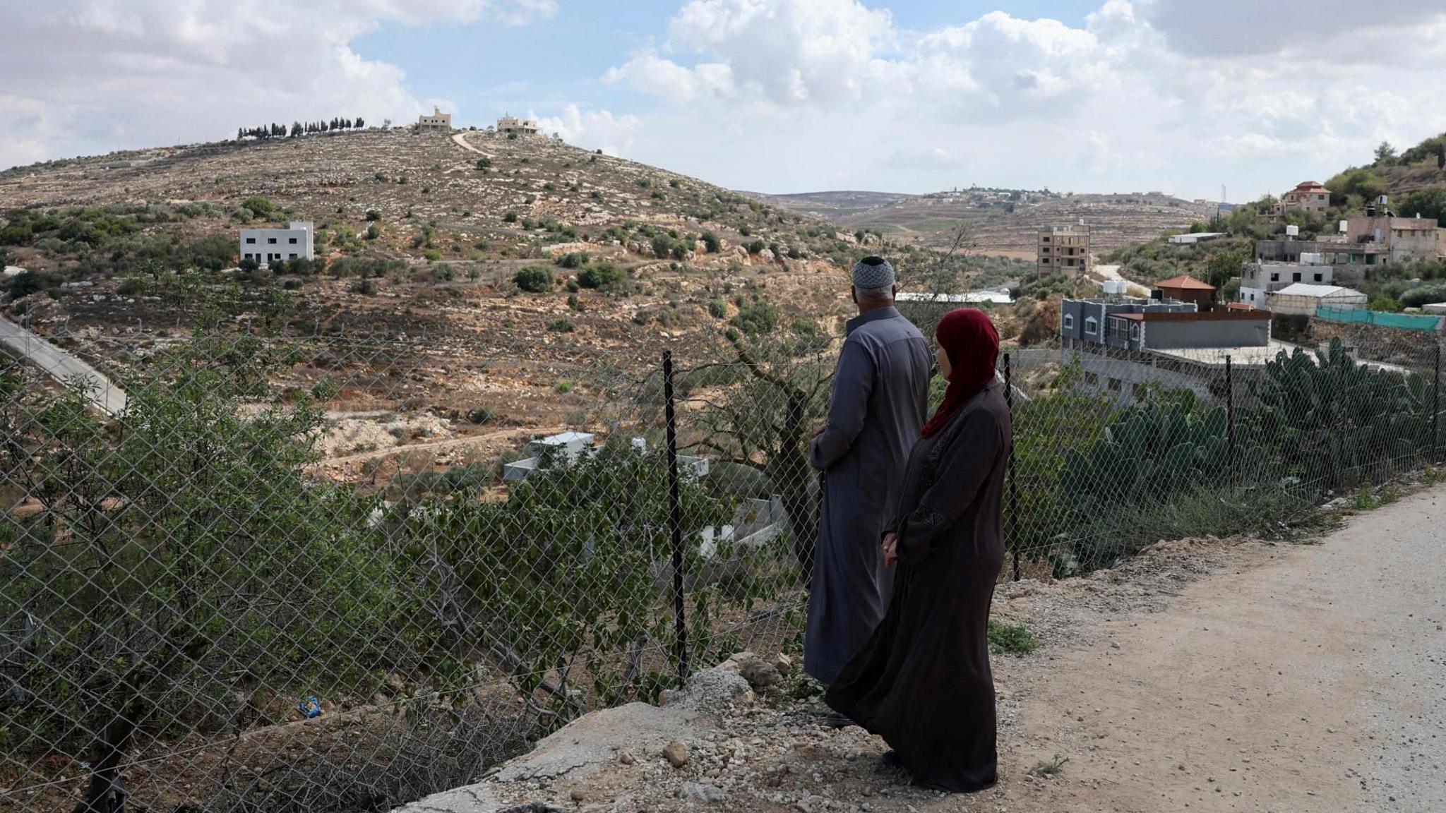 Mahmoud al-Tubasi and his wife Aedah look at their home, which was damaged during an Israeli settler attack, in Jalud, in the occupied West Bank (29 September 2026)