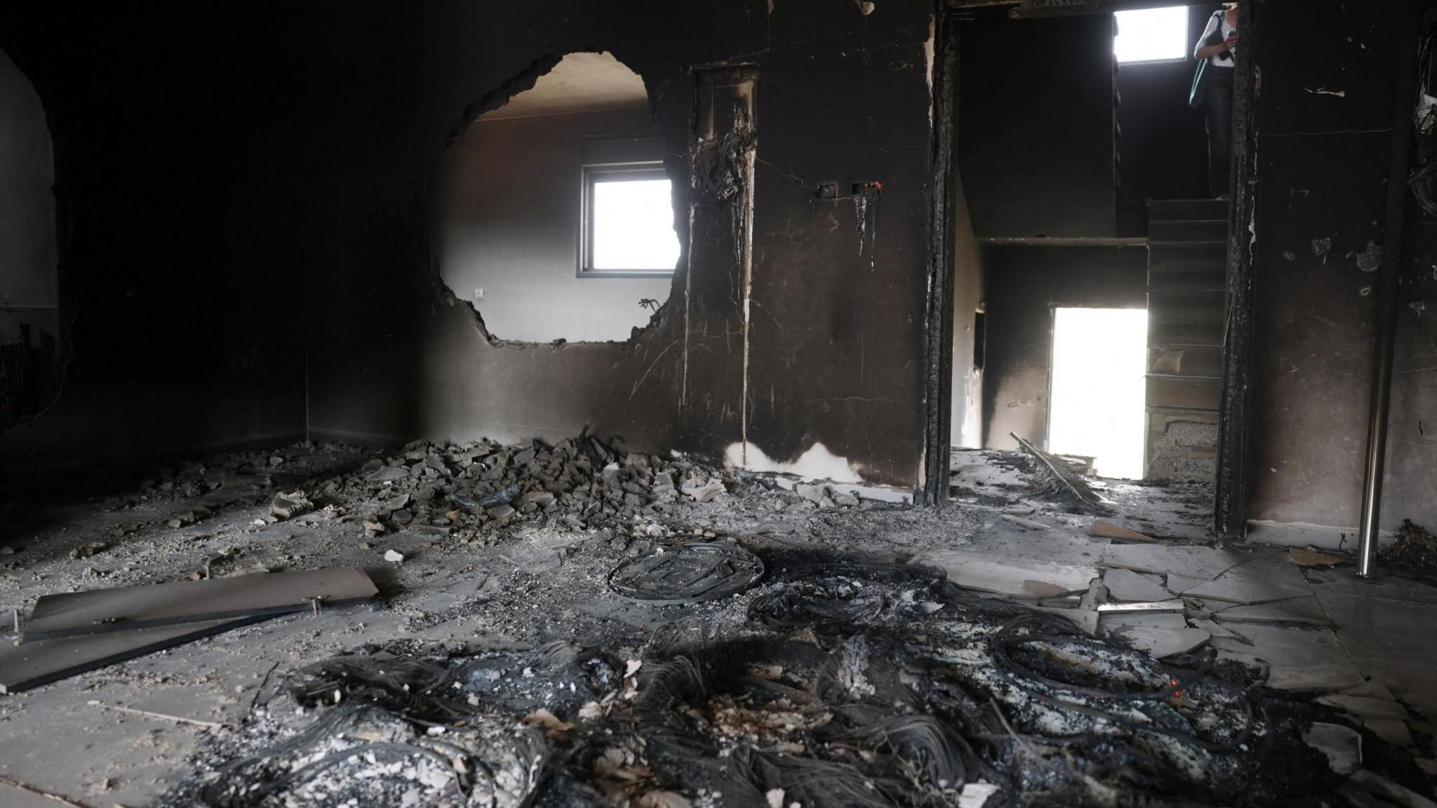 Israeli security forces and journalists inspect a fire-damaged home belonging to the al-Tubasi family, following an Israeli settler attack in Jalud, in the occupied West Bank (29 September 2026)