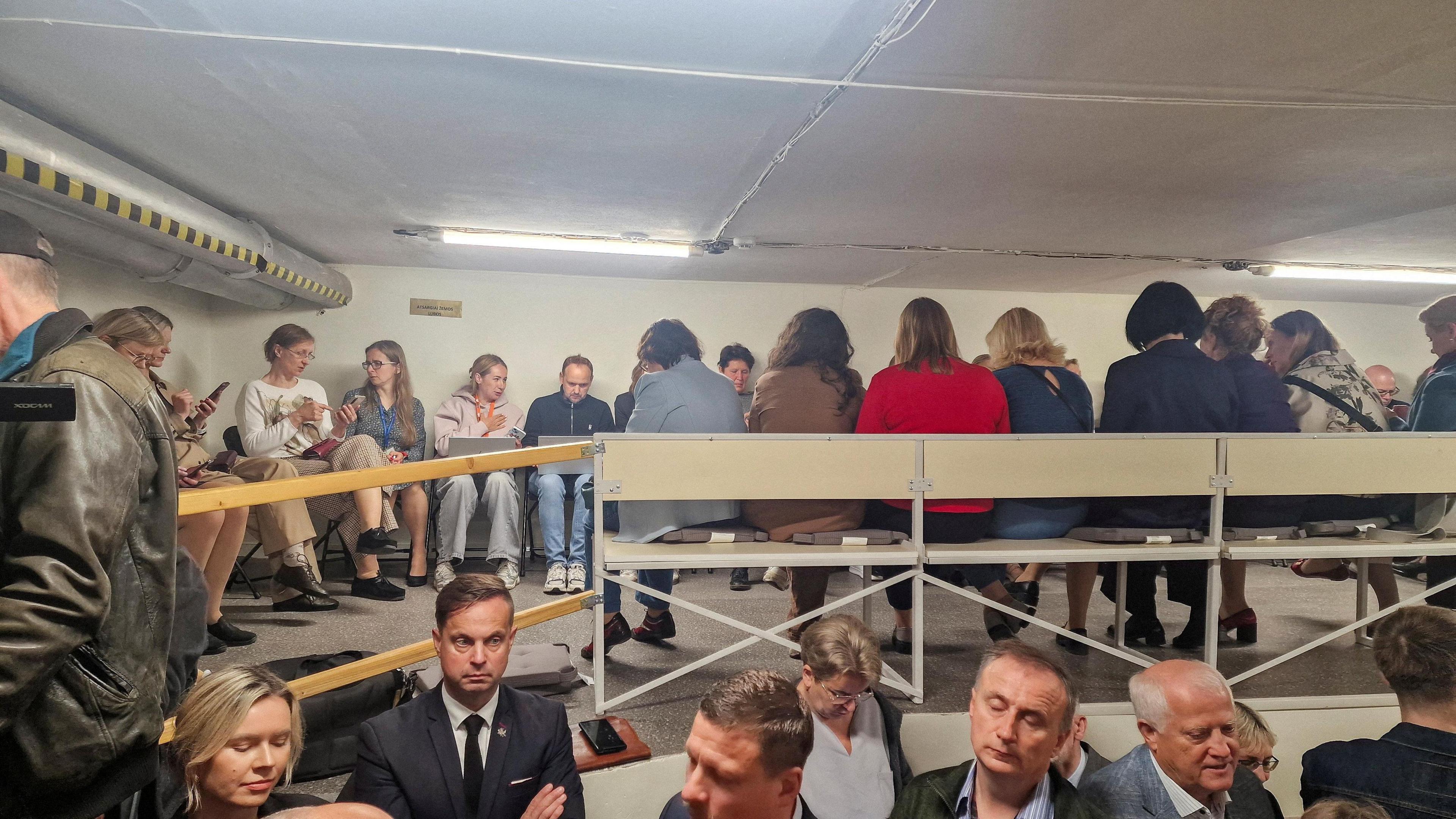People gather inside a shelter at the Lithuanian parliament after an 'air danger' warning.