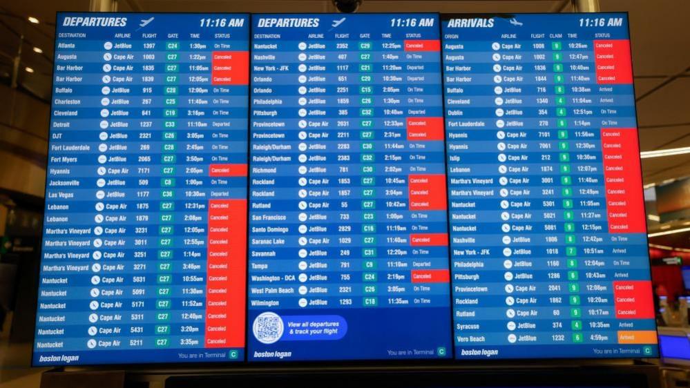 An information board at Boston Logan International Airport shows cancelled flights as a strong nor'easter coastal storm batters the US northeast coast.