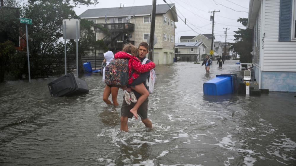 People walk in flooded streets in Surf City, New Jersey, on 26 September 2026