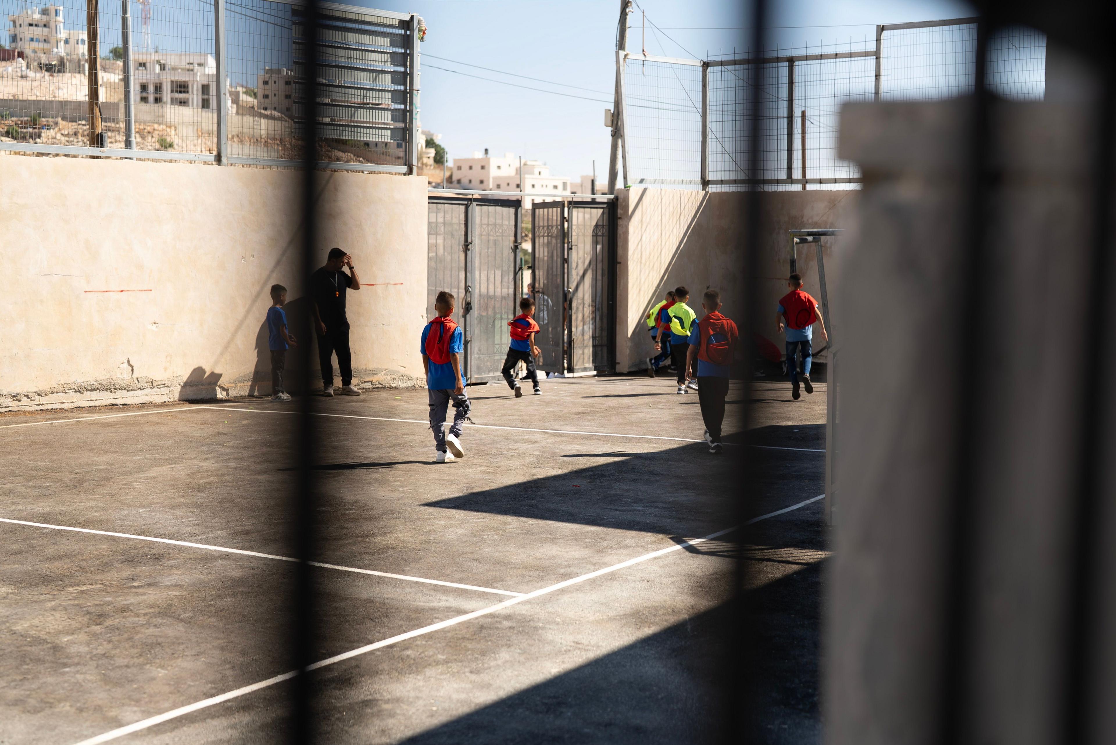 kids play football in playground.