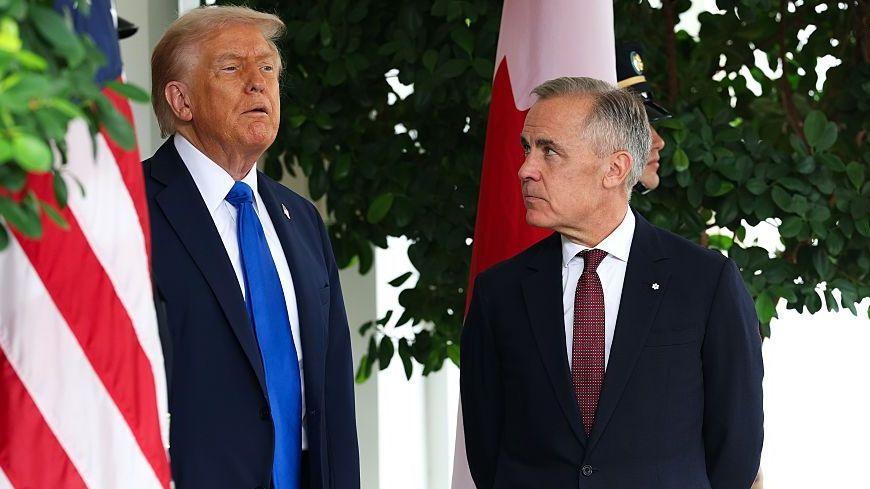 US President Donald Trump speaks to Canadian Prime Minister Mark Carney during a welcome outside the West Wing of the White House in October 2025