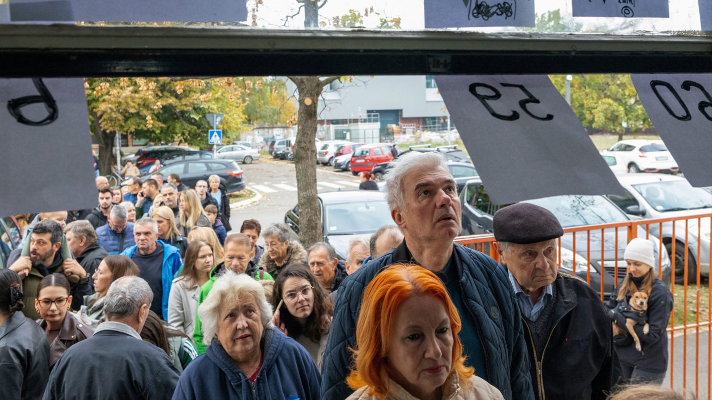 People queue outside a polling station to vote during the parliamentary election in Novi Sad, Serbia,