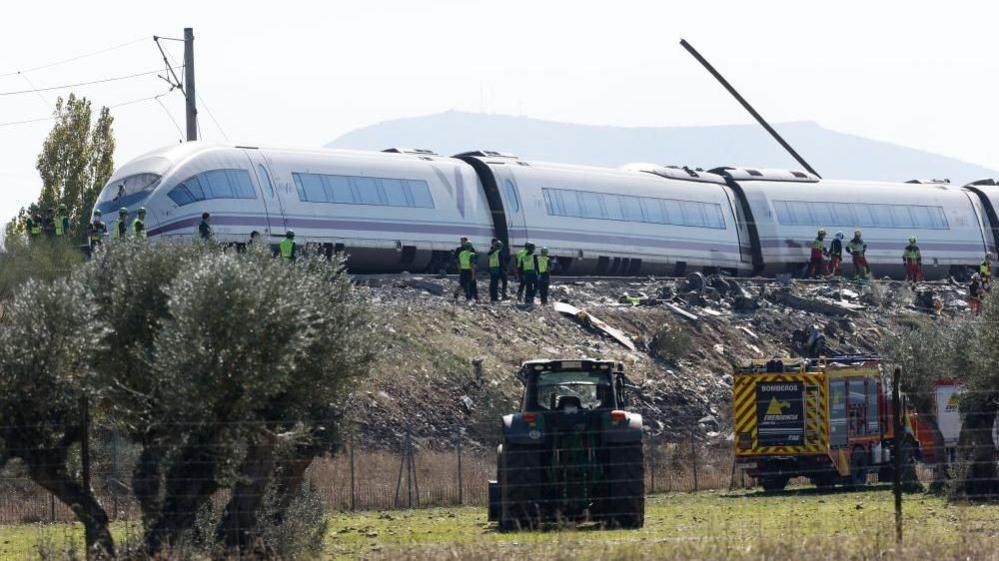 The train showing a long piece of metal sticking up from a carriage