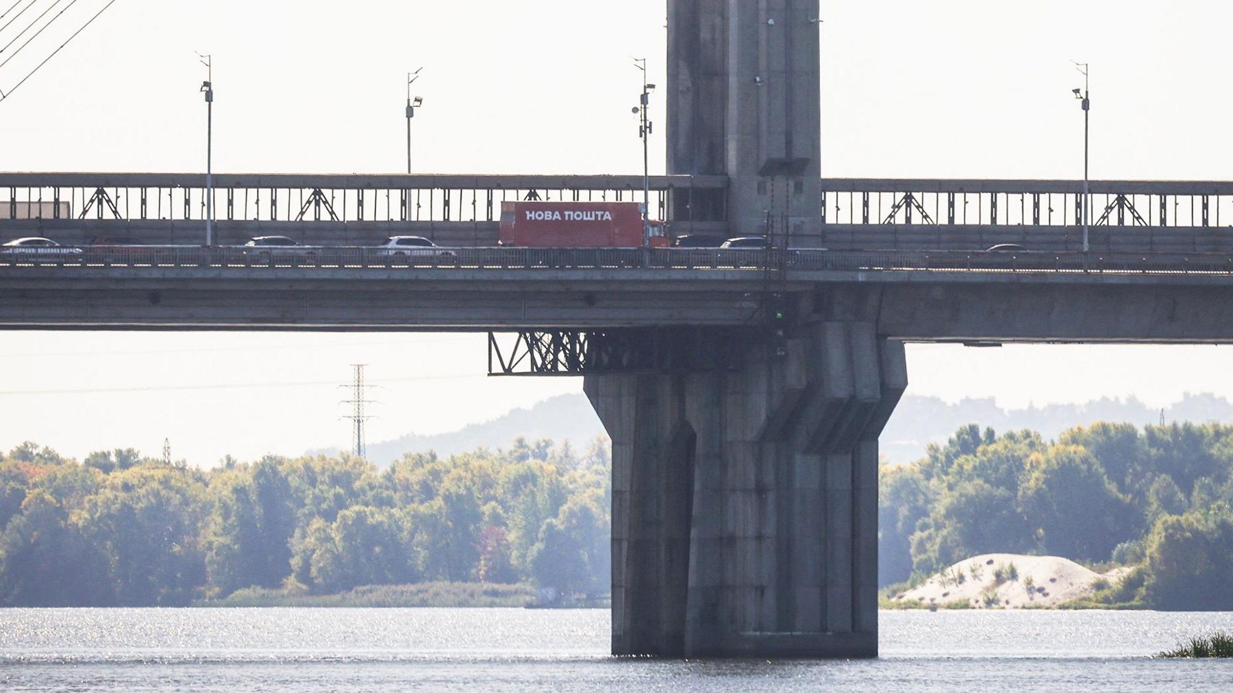 Cars drive across a bridge over the Dnipro River after it was hit during a Russian jet drone strike, amid Russia's attack on Ukraine, in Kyiv, Ukraine