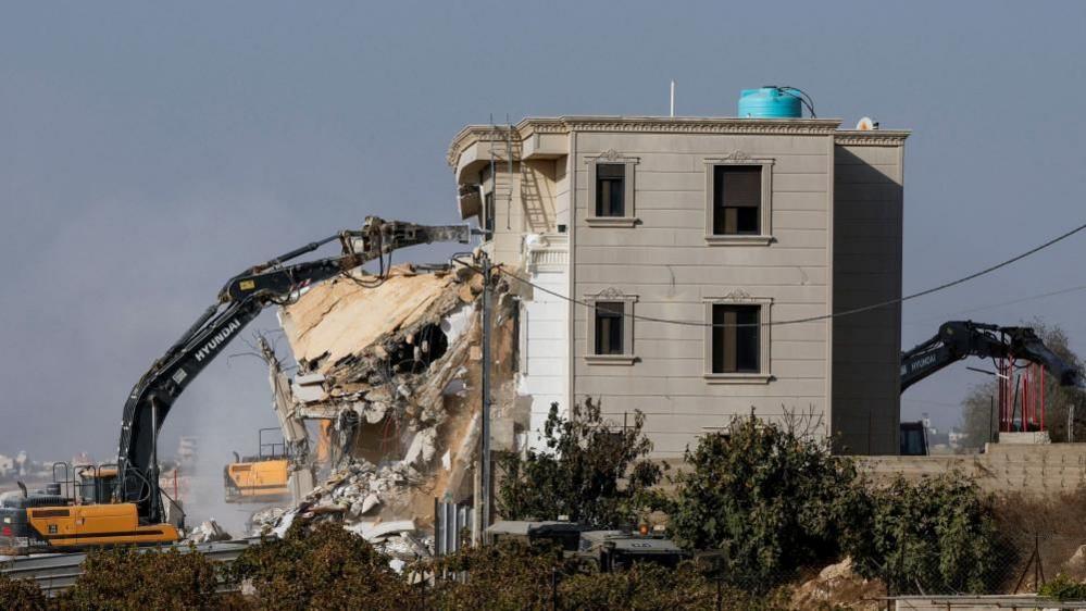 Israeli machinery demolishes a Palestinian house following a shooting attack, in Hebron