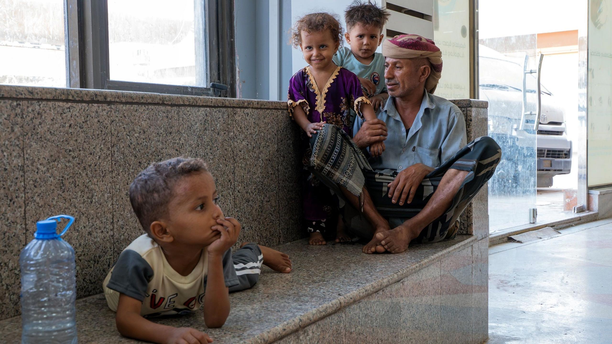 Bajash Ali Sagir Hassan (R) with his young children, at a hospital in Aden, Yemen