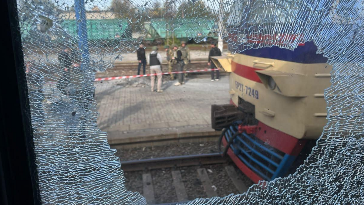 A view from a broken train window shows Ukraine's emergencies officials and soldiers working at the railway platform hit by a Russian drone in the central Ukrainian city of Dnipro. Photo: 29 October 2026
