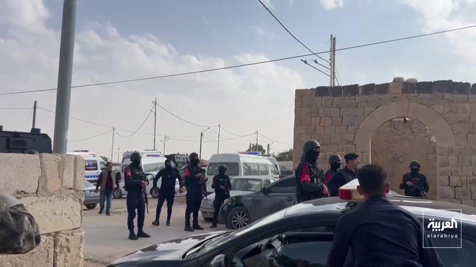 Several security personnel surrounded by cars in a car park in Jordan.