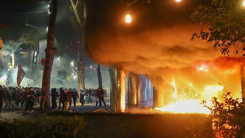 Protesters next to a huge plume of smoke
