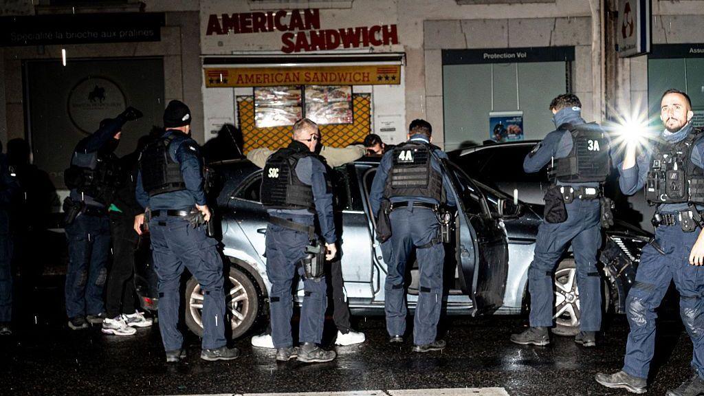 Police stop a vehicle entering the curfew zone after 9 p.m. on Rue de la Barre, just before Place Bellecour in Lyon, France