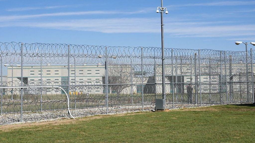A fence, barbed wire and a guard are visible at the Allan B. Polunsky Unit, the prison that houses the men on Texas' death row in Livingston, Texas