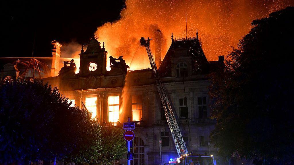 This photograph shows a fire burning and destroying the city hall after a group of individuals forced entry into the building during ongoing protest action against the "high cost of living", in Limoges, central France on October 17, 2026
